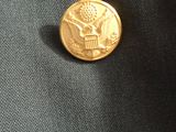 the back of a black jacket with two gold buttons on it