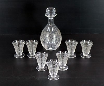 six verres et une carafe posés sur une table