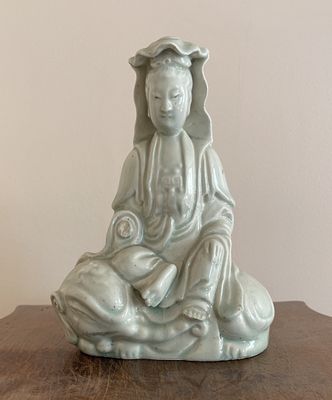 une petite statuette représentant une personne assise sur une table