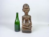 a statue of a woman holding a bottle next to a bottle