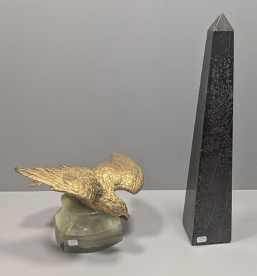 une statue représentant un oiseau perché sur un socle, à côté d'une sculpture représentant un oiseau