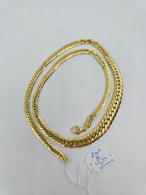 un ensemble composé d'un collier et d'un bracelet plaqués or, posé sur un fond blanc