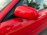 a close up of a red car ' s side view mirror