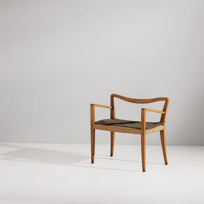 une chaise en bois avec une assise noire dans une pièce blanche