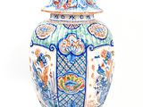 a large blue and white vase with a bird on top of it