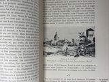 an open book with a picture of a village in the background