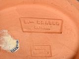 a clay pot with a lid that has a tag on it