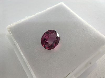 a close up of a pink sapphire stone on a white surface