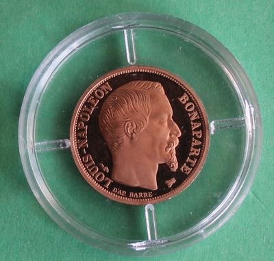un gros plan d'une pièce de monnaie placée dans un étui transparent posé sur une surface verte