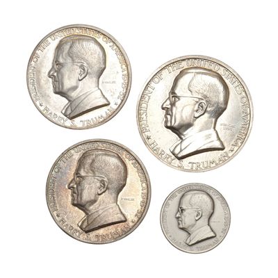 four different types of silver coins on a white surface