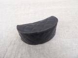 a black purse sitting on a bed with a white blanket
