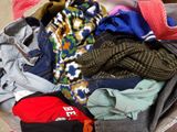 a suitcase full of clothes and a hat on the floor