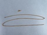 a close up of a gold chain on a white surface