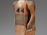 an old wooden statue of a man holding a piece of wood