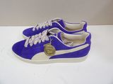 purple and white puma sneakers on a white surface