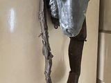 a statue of a sheep with a bell attached to it ' s head