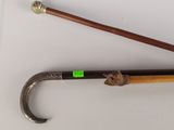 two old canes and a cane stick on a white surface