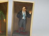 two miniature figurines of a man in a suit and tie