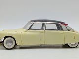 yellow toy car with black roof and white rims on a white surface