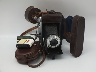 un appareil photo et une paire de chaussures posés sur une table