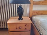 une lampe posée sur une table de chevet à côté d'un lit