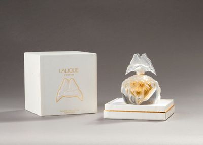 a small perfume bottle sitting on top of a white box