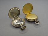 deux petites montres de poche en argent posées sur une table