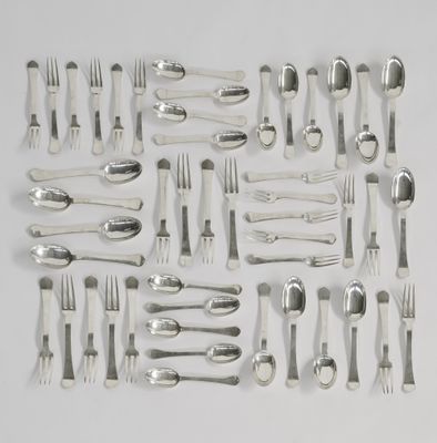 de nombreuses fourchettes et cuillères disposées sur une surface blanche