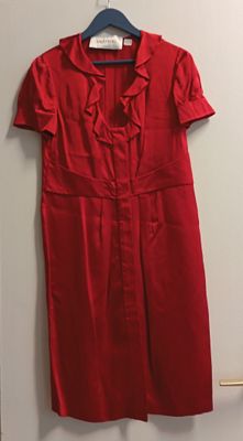 une robe rouge suspendue à un cintre dans une pièce