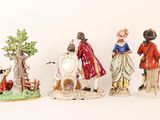 five figurines of people standing next to each other