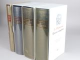 three books sitting on top of each other on a white surface