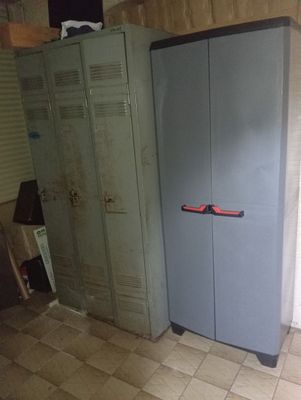 une armoire bleue dans un coin de la pièce, avec une poignée rouge