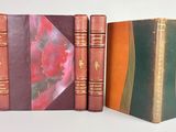 trois livres sont empilés sur une surface blanche