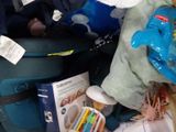 a blue suitcase filled with baby items on the floor