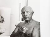 a black and white photo of an old man holding something