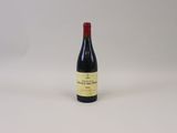 une bouteille de vin rouge posée sur une table blanche