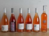 plusieurs bouteilles de vin sont alignées sur une table en bois