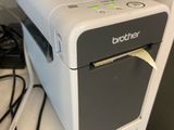 une petite imprimante posée sur une étagère à côté d'un téléphone