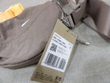 a bag with a price tag on it sitting on a bed