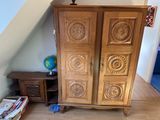a wooden armoire in the corner of a room