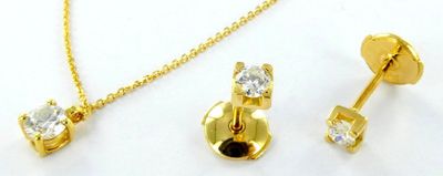 trois bijoux en or posés sur une surface blanche