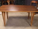 a wooden table with chairs around it in a room