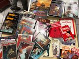 un grand nombre de livres posés sur le sol