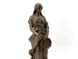 bronze statue of a woman with a basket of flowers on her lap