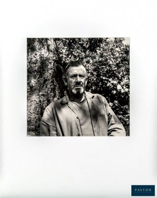 black and white photograph of a man with a beard in front of a tree