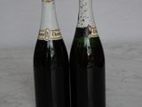 two bottles of champagne sitting on a marble table