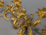 pair of antique gold leaf wall sconces on a grey background