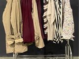 beaucoup de vêtements suspendus à une étagère dans une pièce