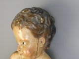 une petite statue représentant un enfant tenant un ours en peluche