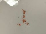 a white plate with red writing on it on a table